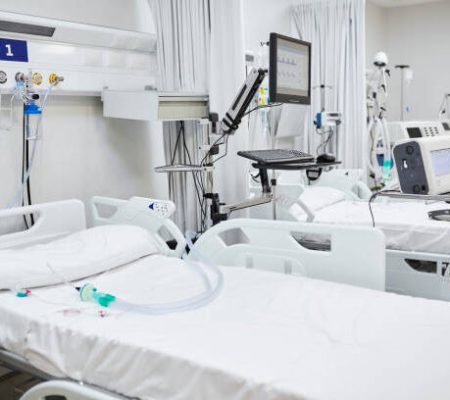 Empty bed in intensive care unit. Various medical equipment in ward. Interior of hospital.